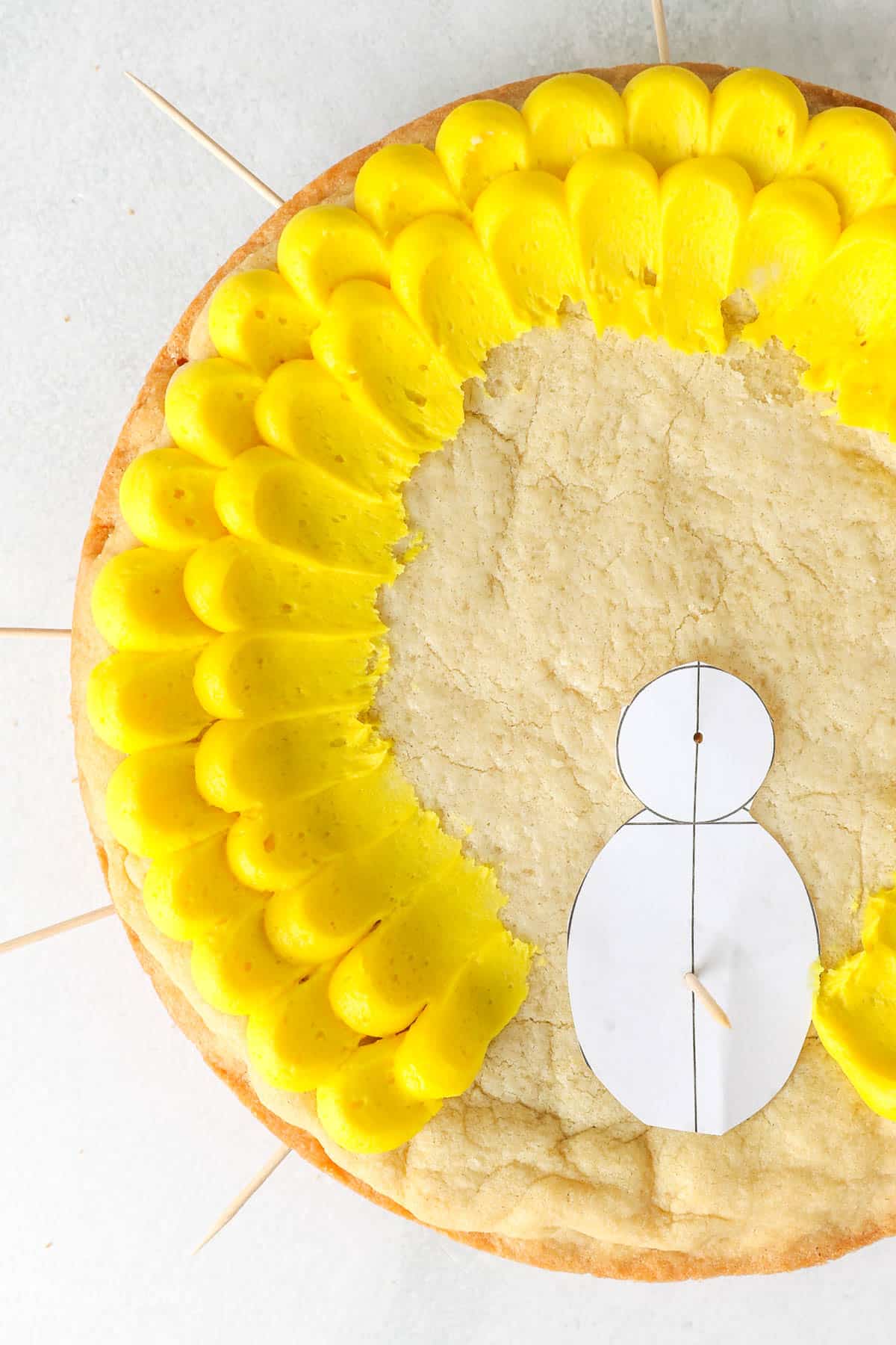 Overhead shot of a cookie cake with yellow buttercream pedal frosting technique