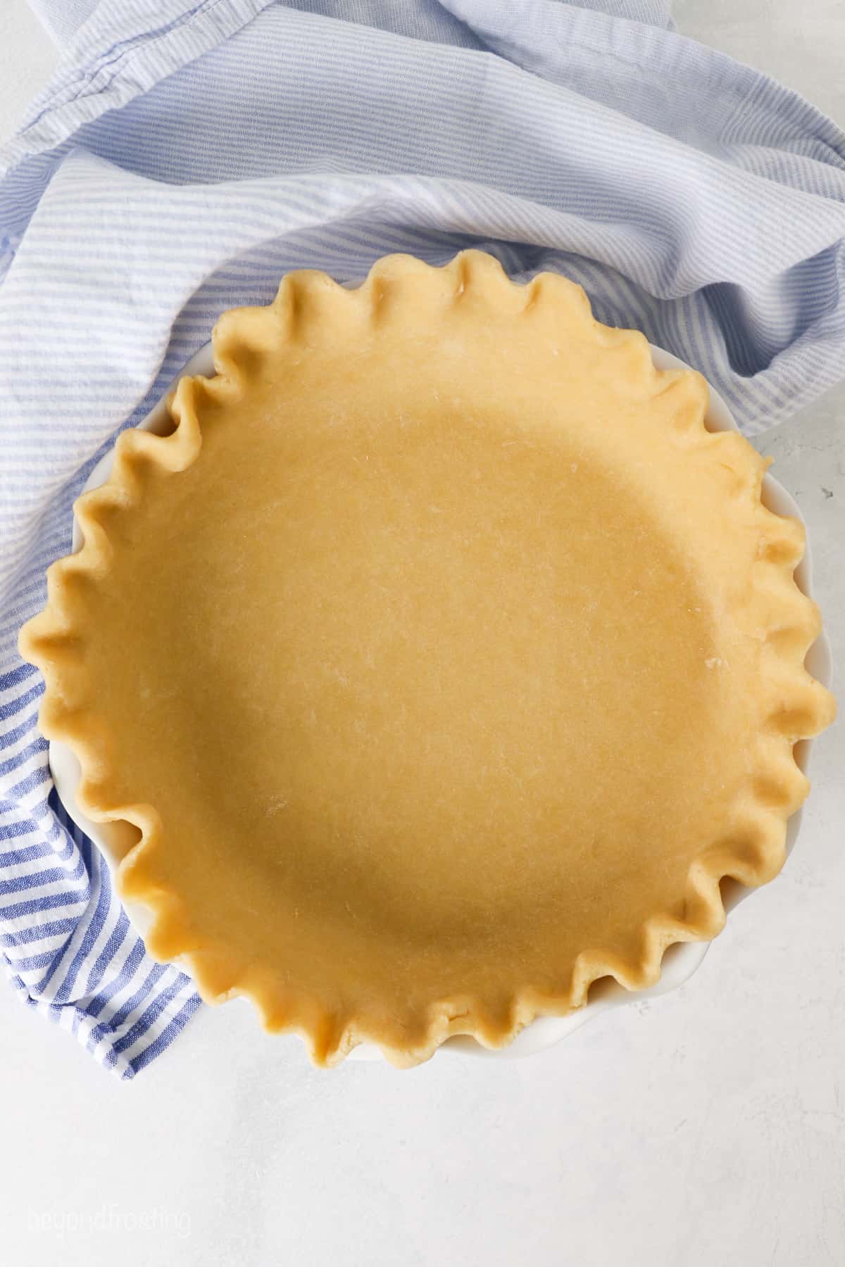 Overhead view of an unbaked pie crust in a pie plate.