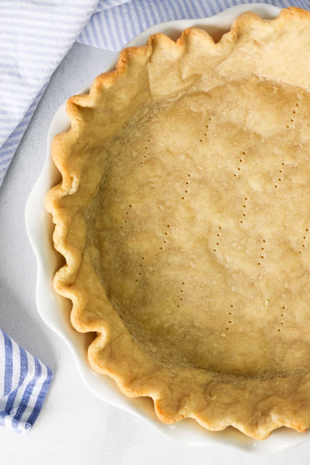 Overhead view of a partially baked pie crust in a pie plate.