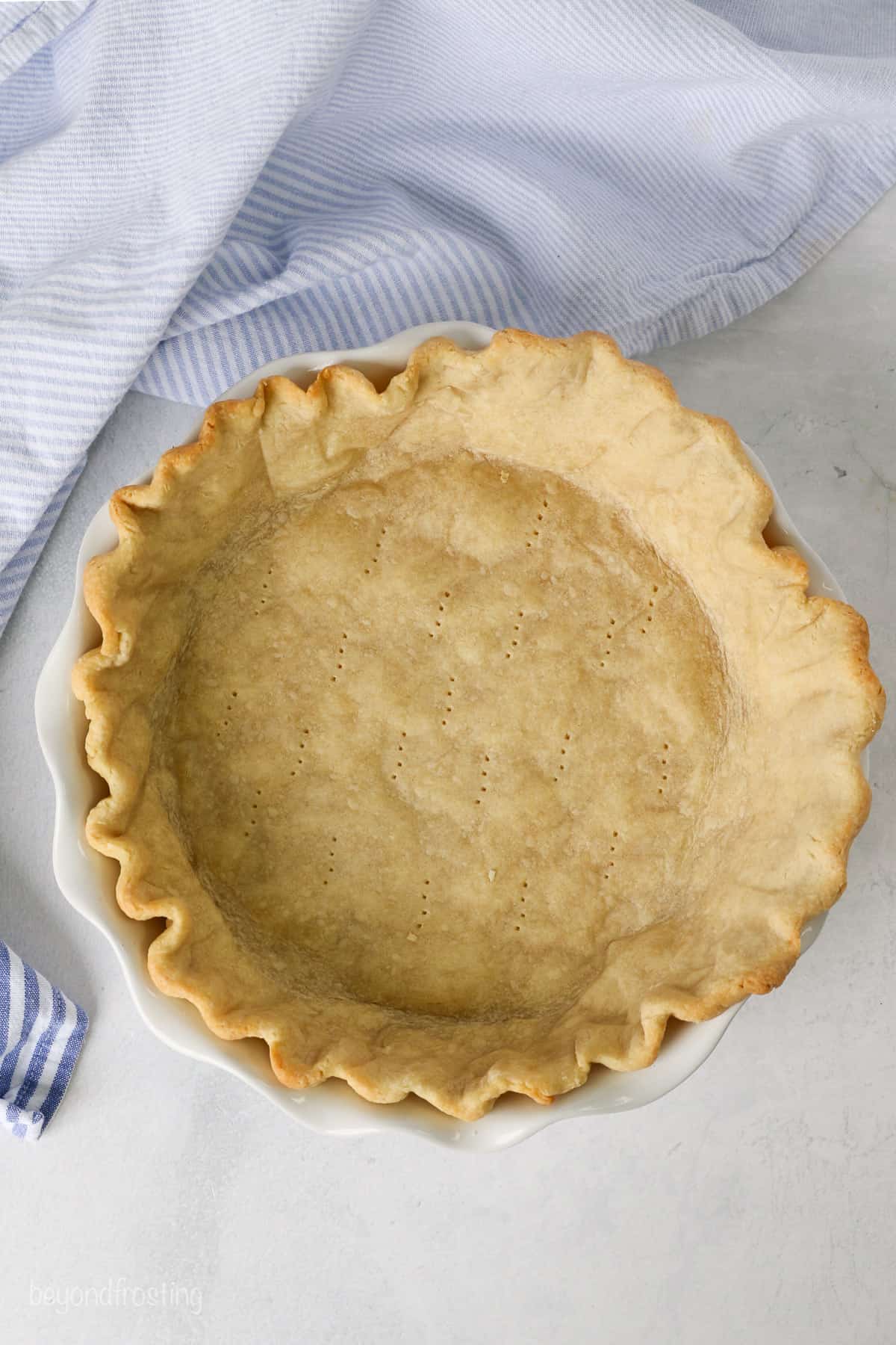 Overhead view of a partially baked pie crust in a pie plate.