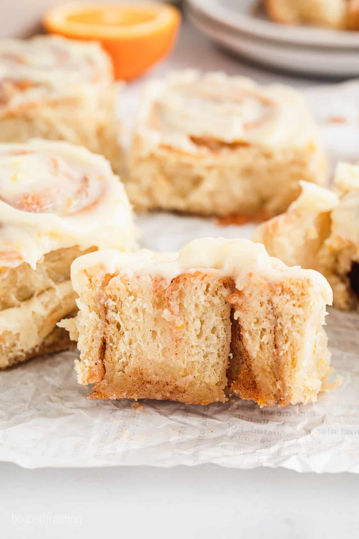 Close up of an orange roll cut in half, with more rolls in the background.
