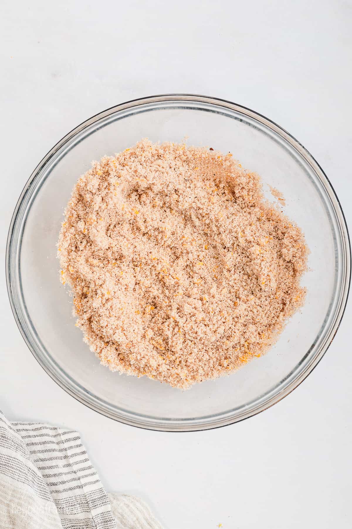 Orange zest and cinnamon sugar combined in a glass bowl.