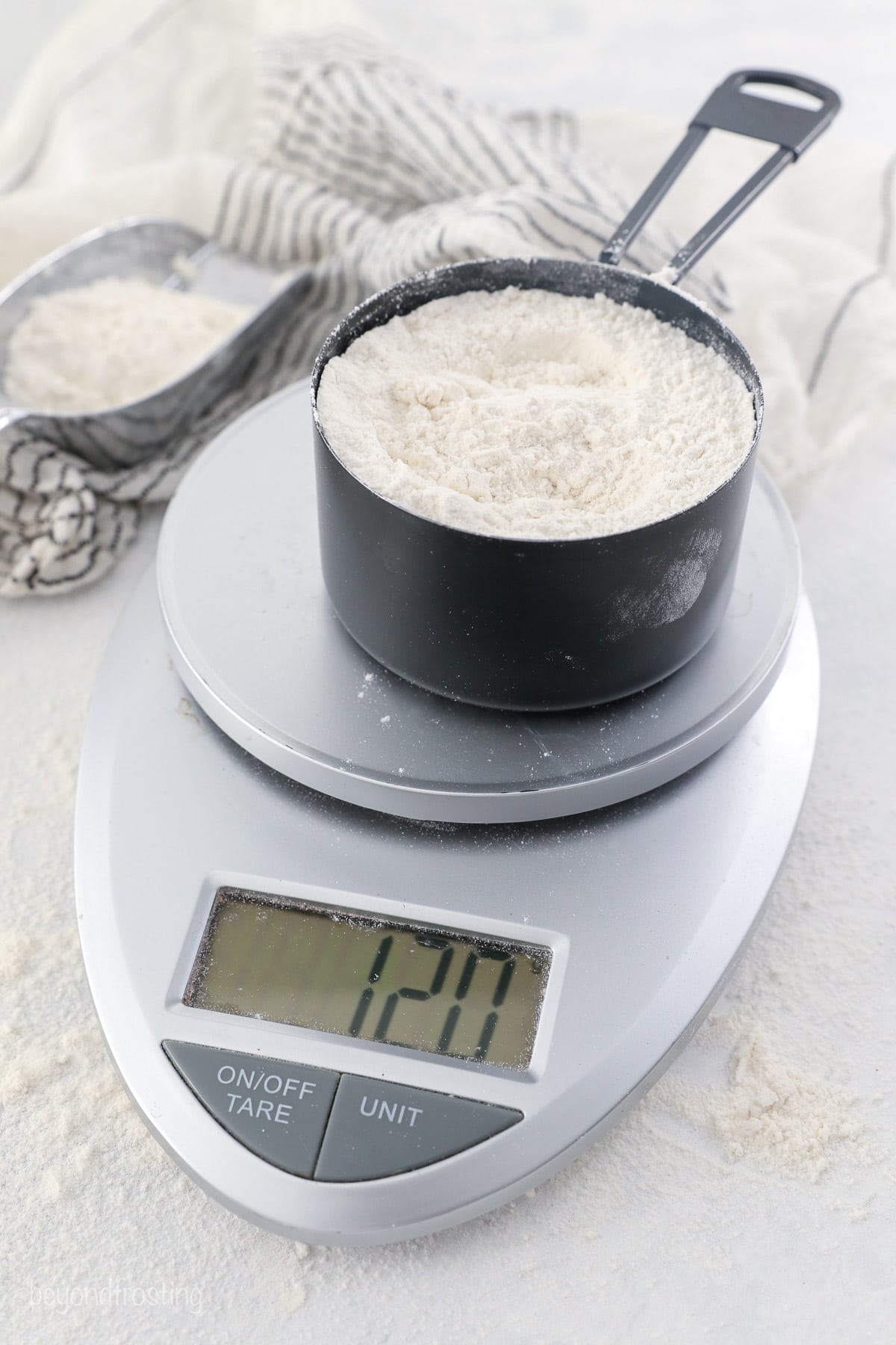 A measured cup of flour of a kitchen scale, showing 120g