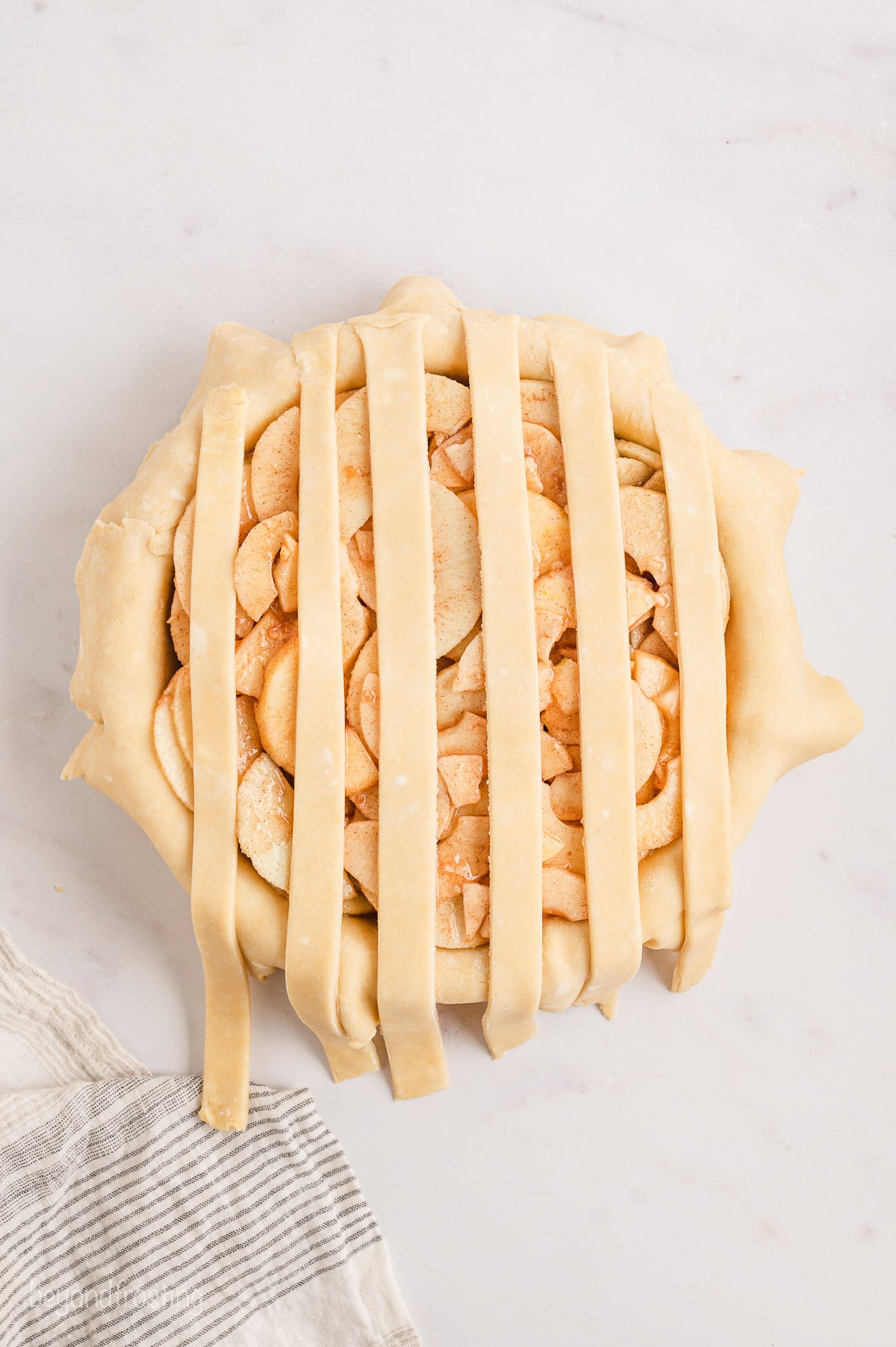 Pie crust strips placed over a pie shell filled with pie filling.