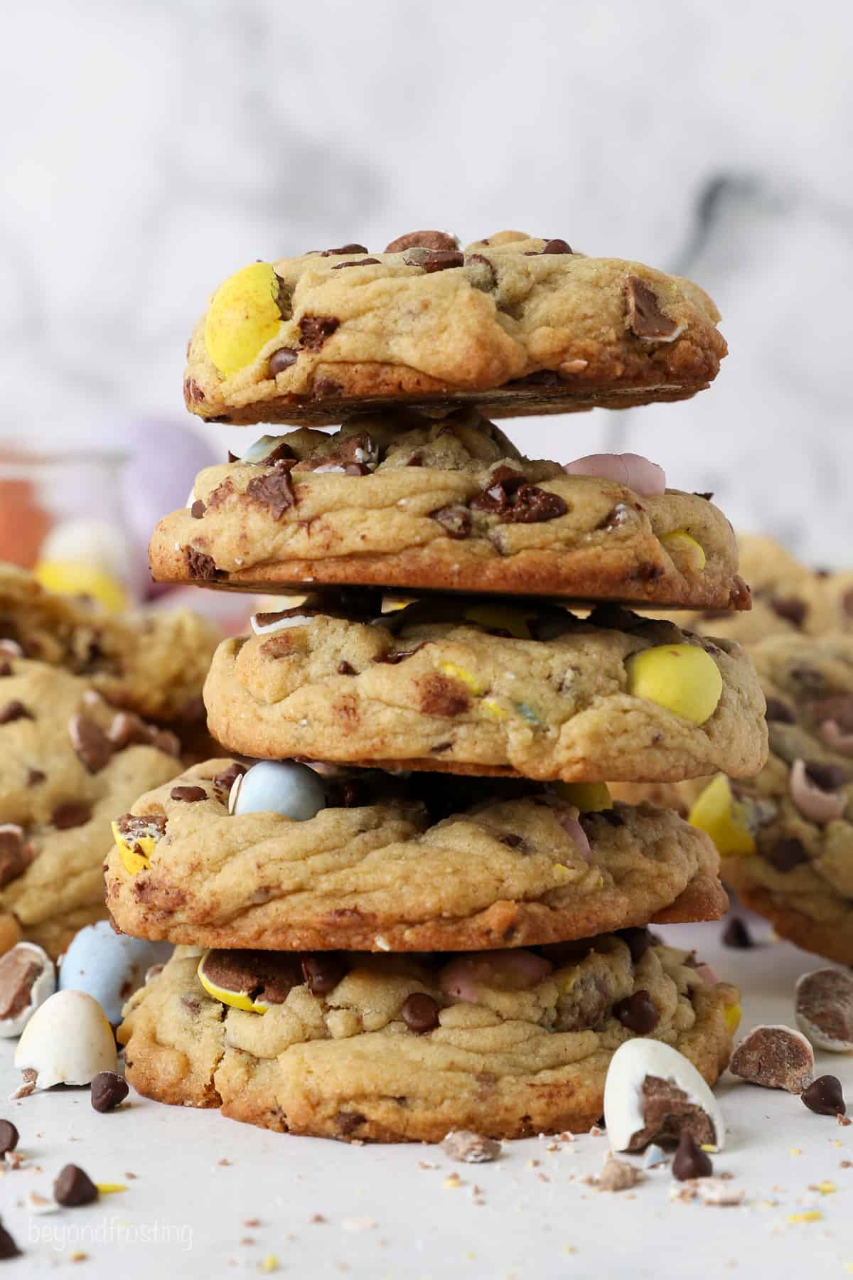 A stack of 5 thick chocolate chip cookies loaded with Cadbury Mini Eggs