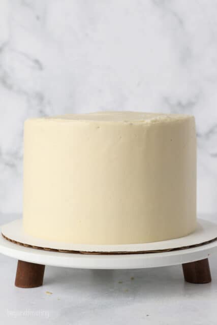 Frosted banana layer cake on a cake stand.