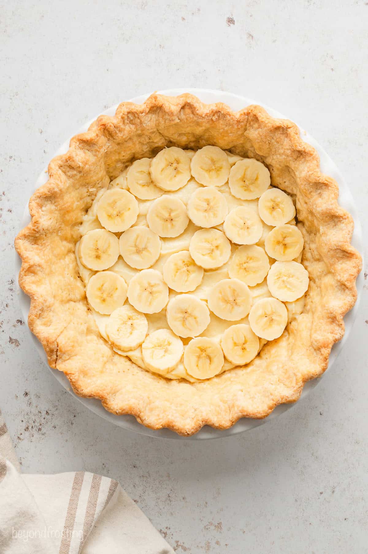 Banana slices layered over the pudding base inside a pie crust.