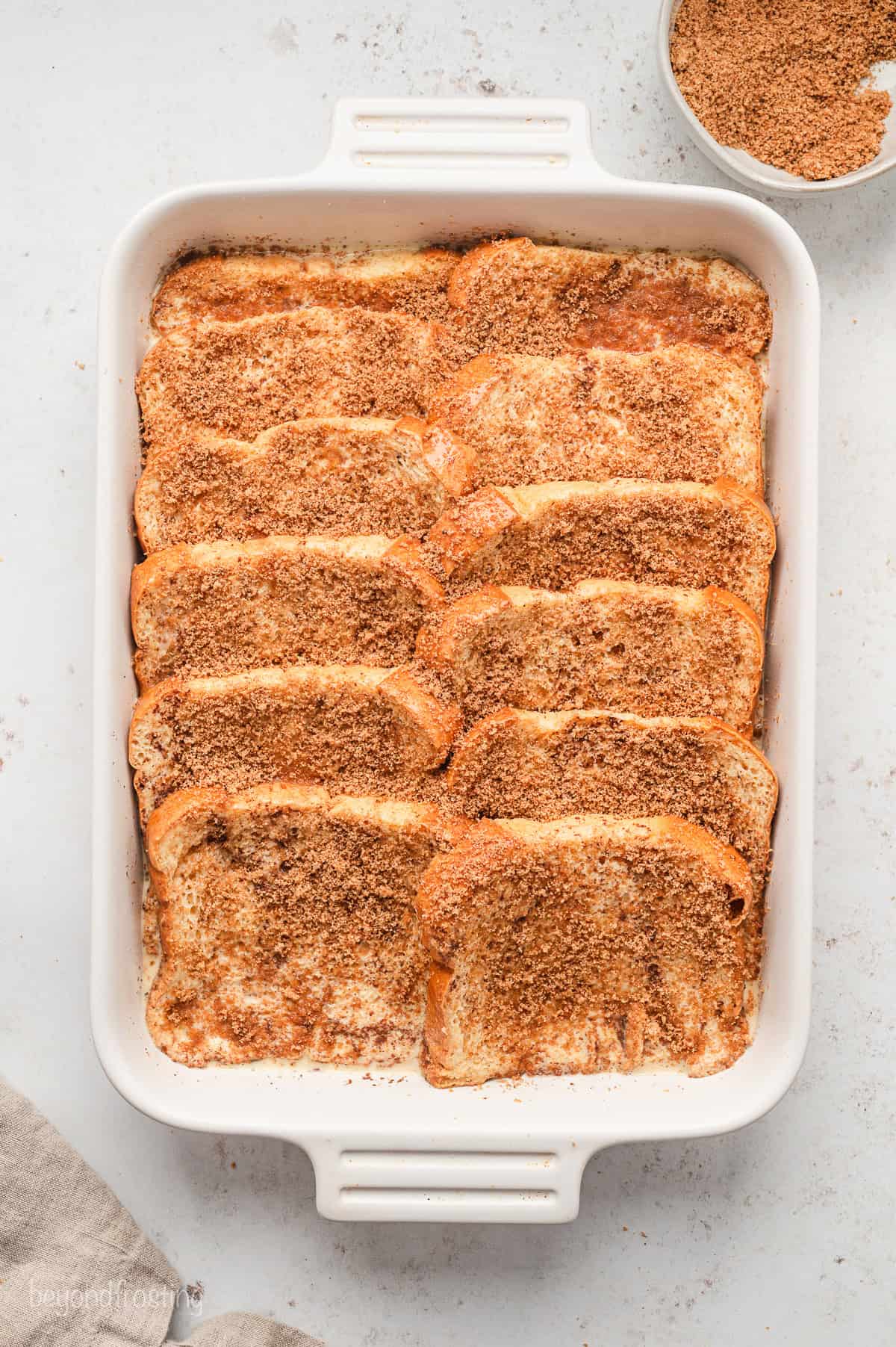 Assembled, unbaked brioche French toast casserole in a baking dish.