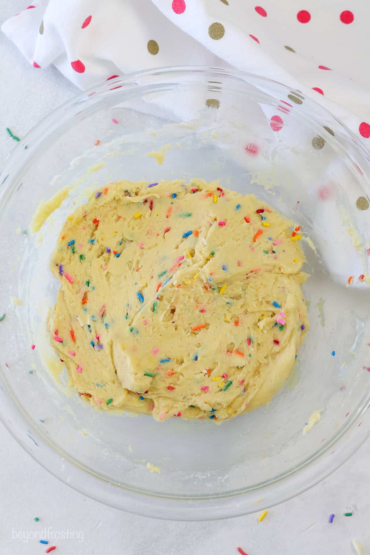 Funfetti cookie dough in a glass mixing bowl.