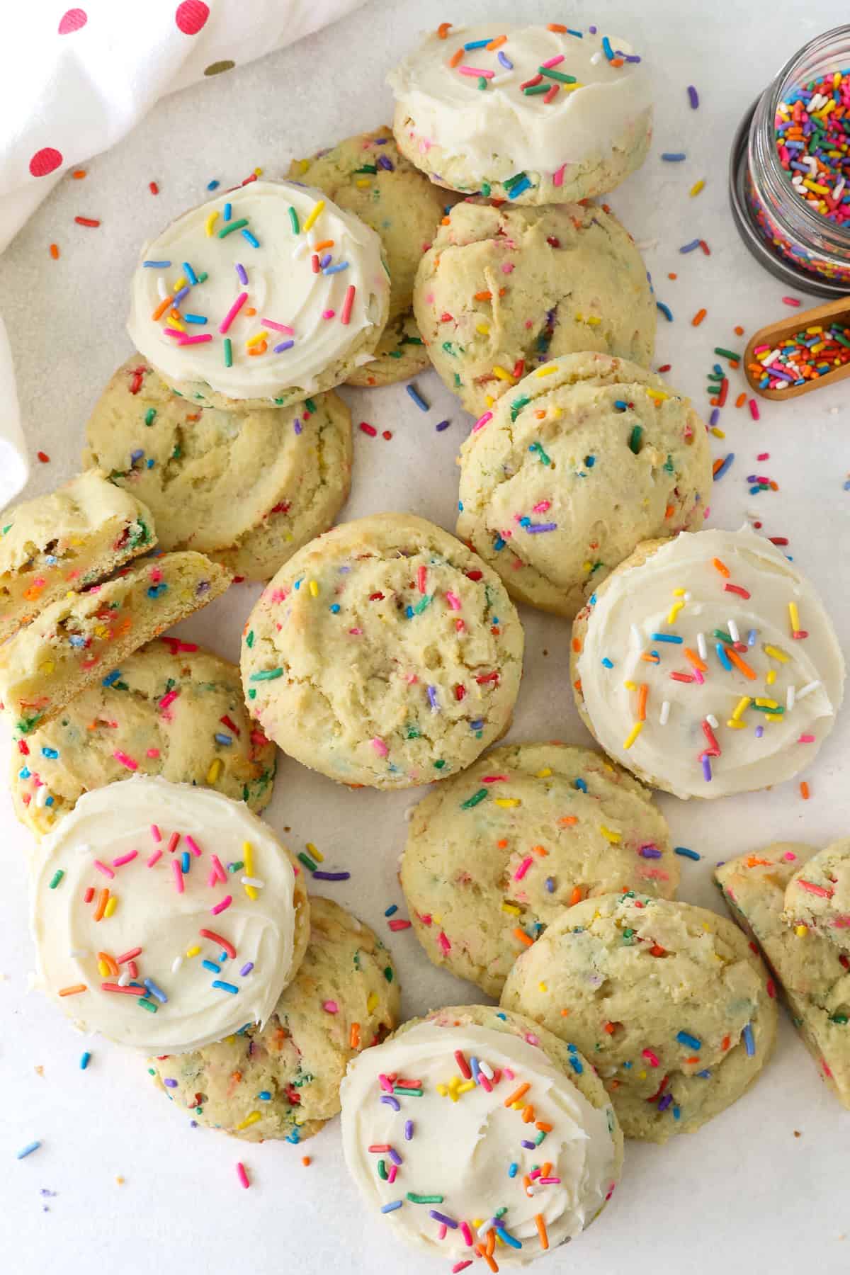 Overhead view of assorted funfetti cake mix cookies, some frosted and decorated with sprinkles.