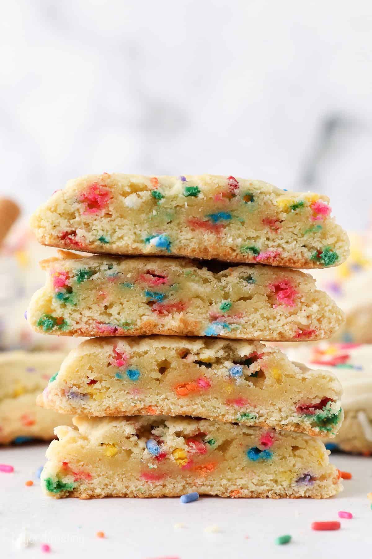 A stack of funfetti cookies cut in half to reveal the cakey interiors.