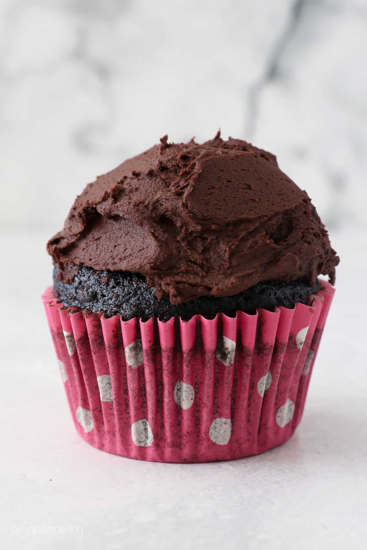 A chocolate cupcake topped with chocolate frosting.