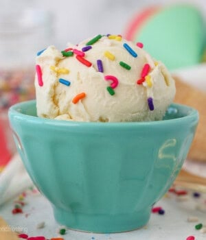 A teal bowl filled with ice cream and sprinkles