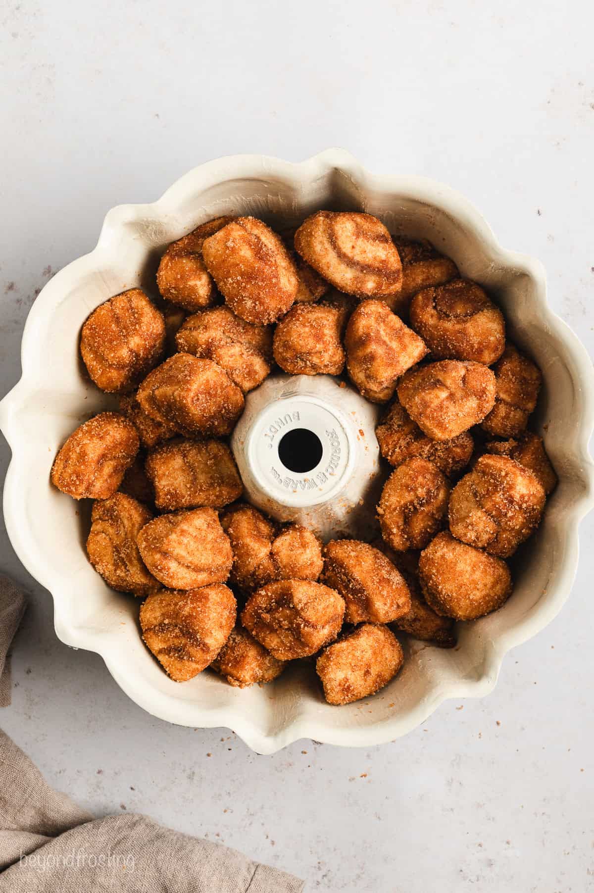 Overhead view of cinnamon roll monkey bread dough assembled inside a bundt pan.