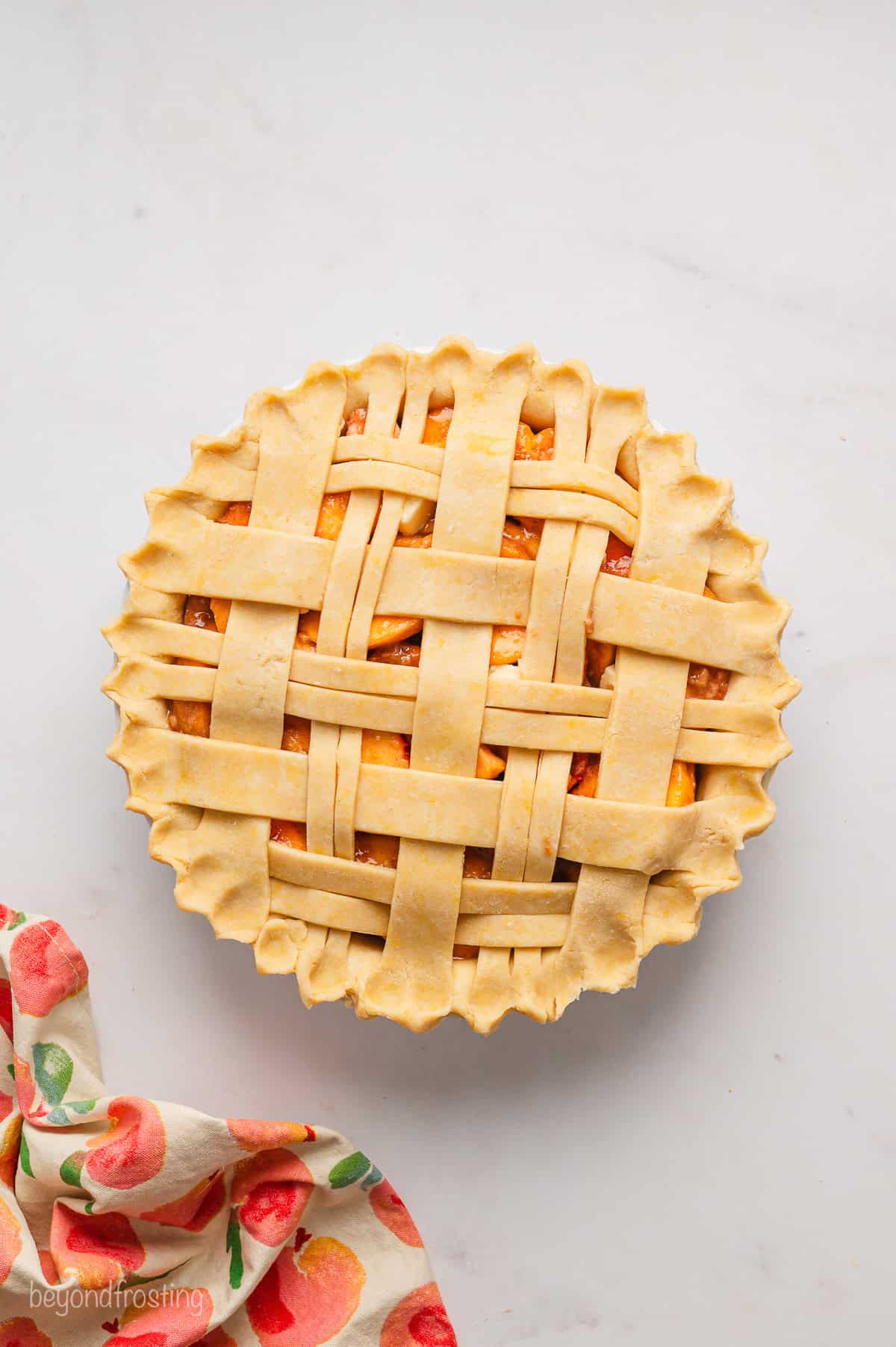 Overhead view of an unbaked peach pie with a lattice crust.