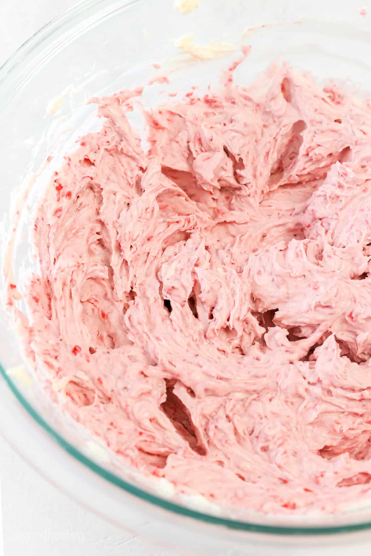 Strawberry cheesecake batter in a glass mixing bowl.