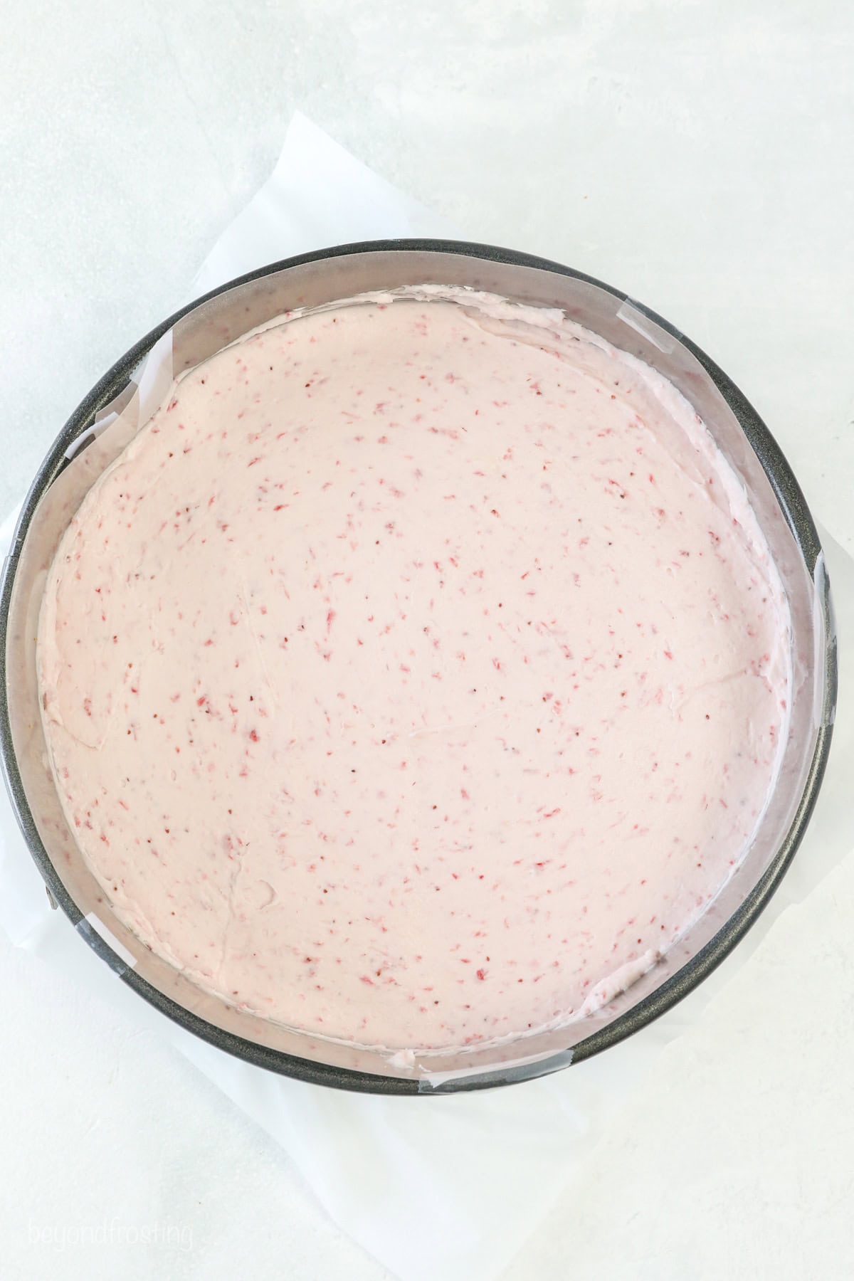 Overhead view of no-bake strawberry cheesecake in a springform pan.