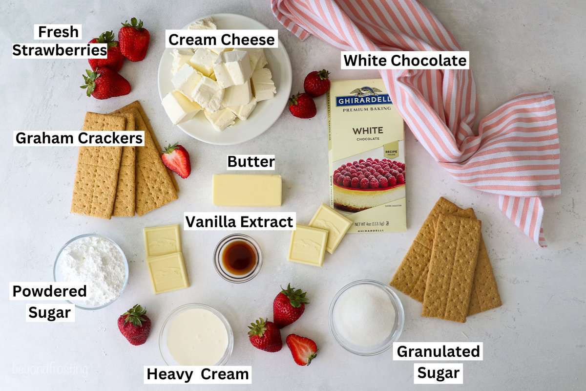 Ingredients for No-Bake Strawberry Cheesecake laid out on a table on bowls and plates with text overlay