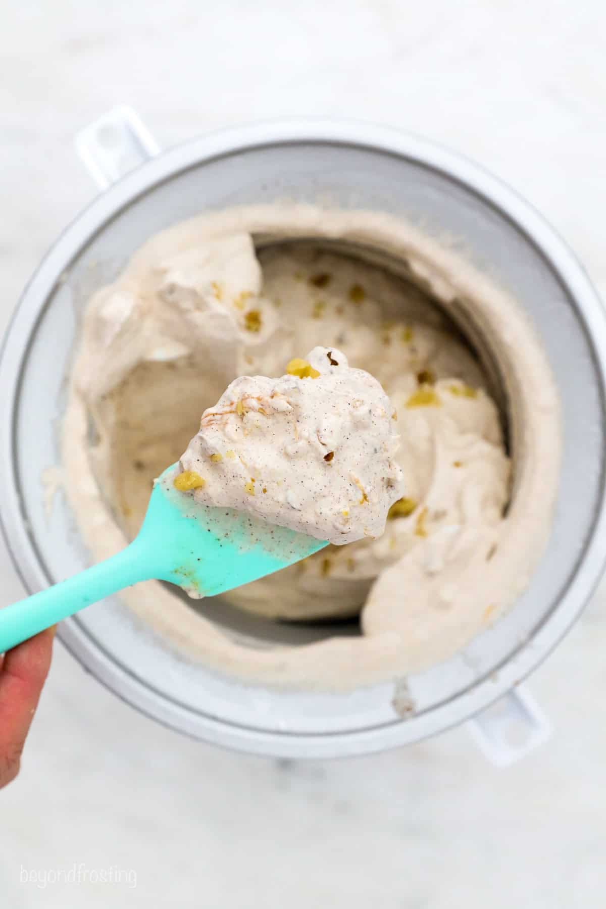 a spatula with a scoop if freshly churned peach walnut ice cream