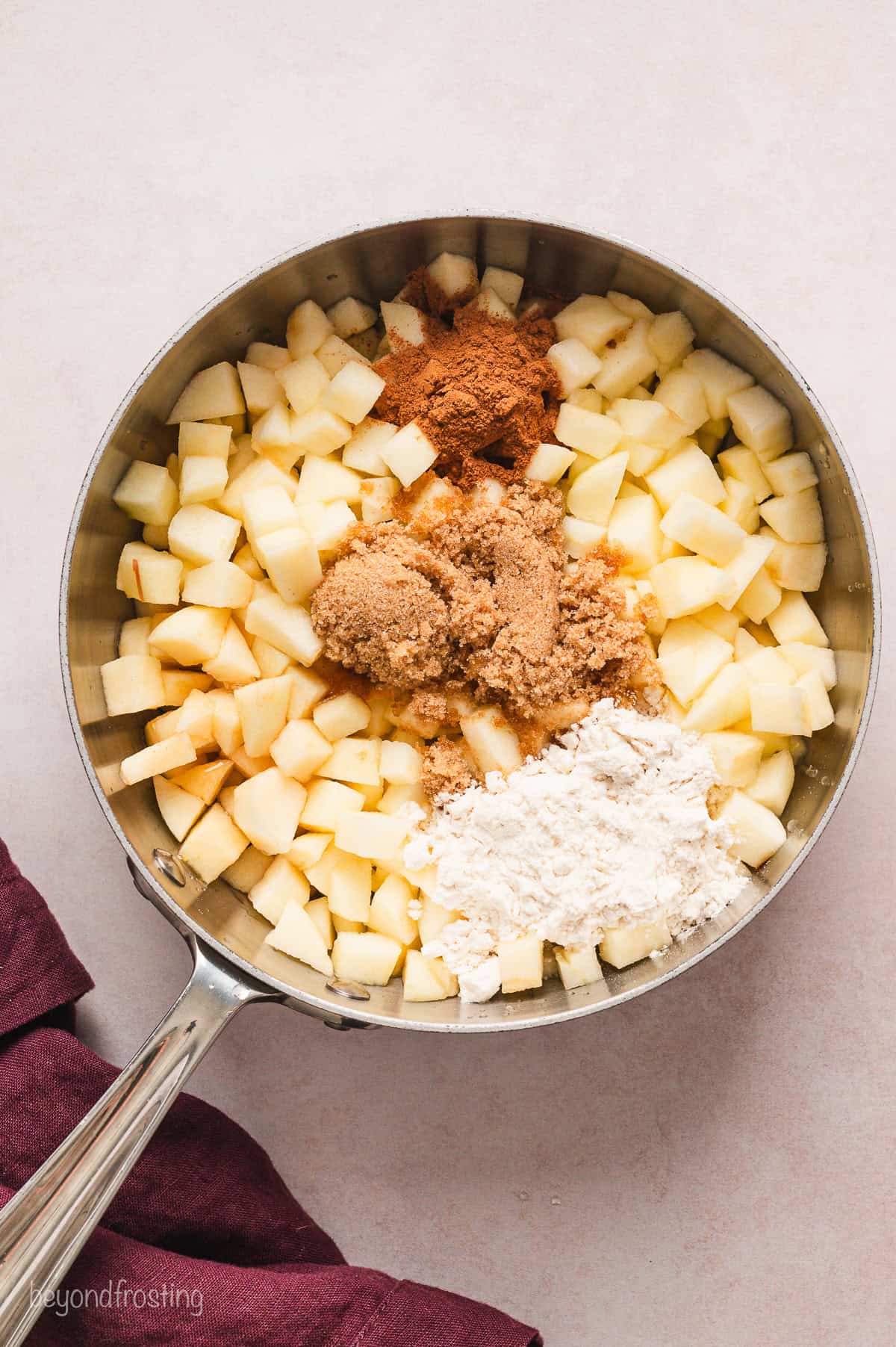 Diced apples combined with dry filling ingredients in a saucepan.