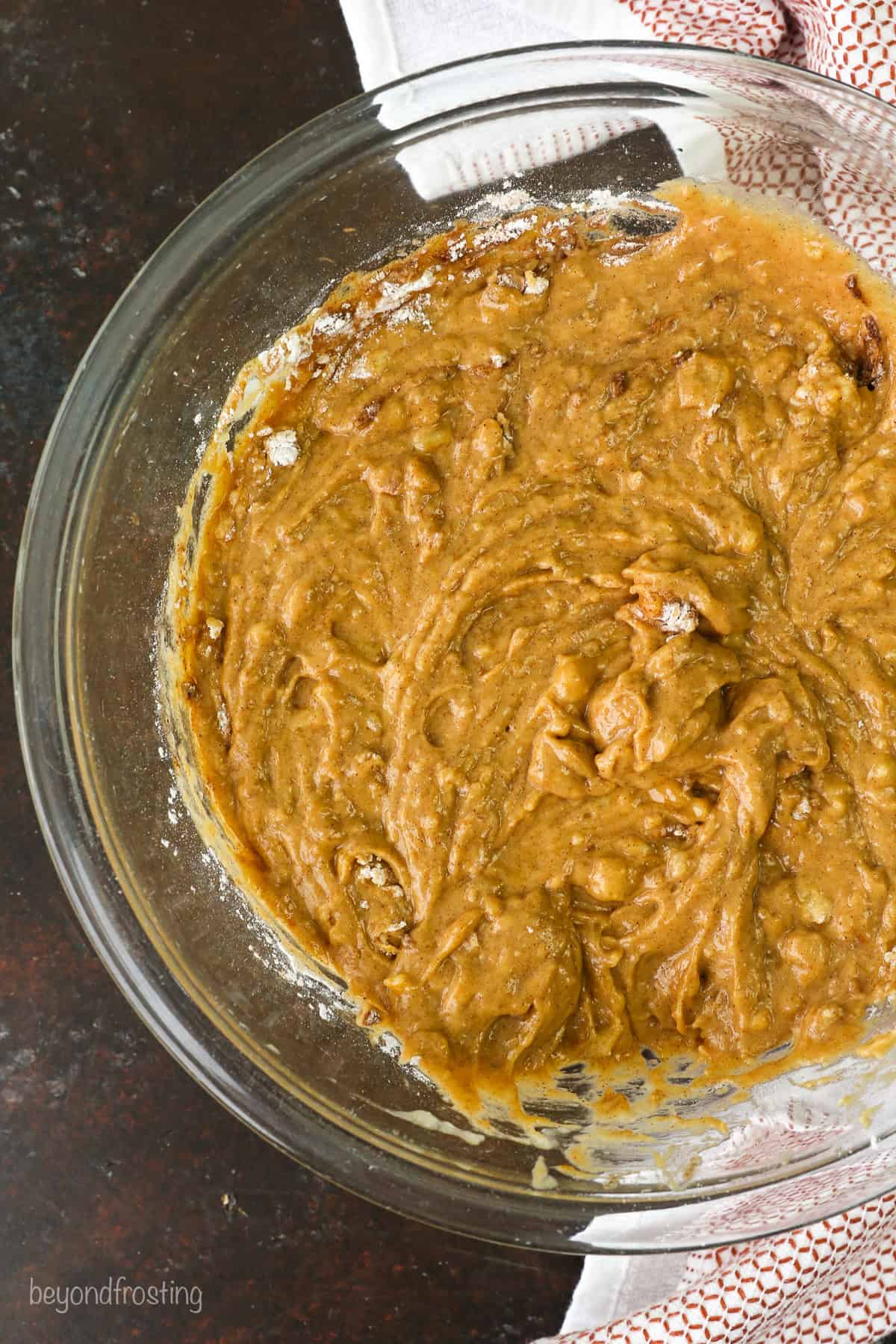 Pumpkin banana bread batter in a glass mixing bowl.