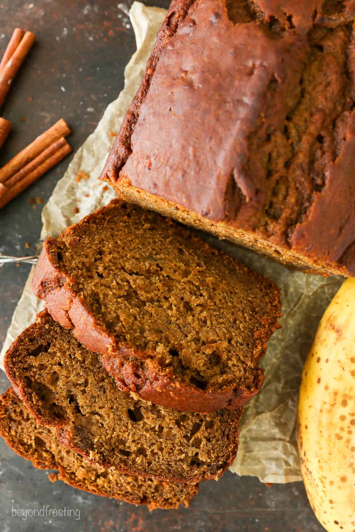 Overhead view of a loaf of pumpkin banana bread cut into slices.