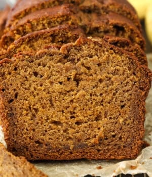 Front view of a loaf of pumpkin banana bread cut into slices.