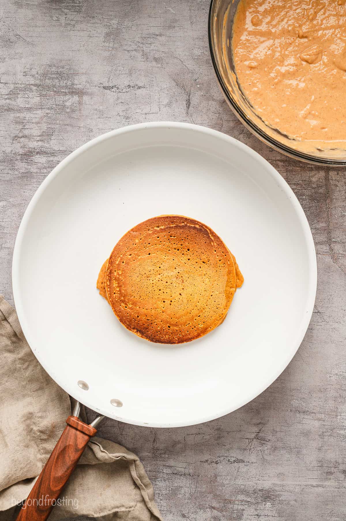 A pumpkin pancake in a white skillet.