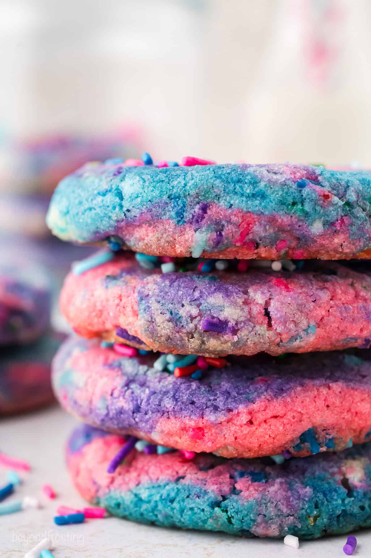 Close up of a stack of four rainbow unicorn cookies.