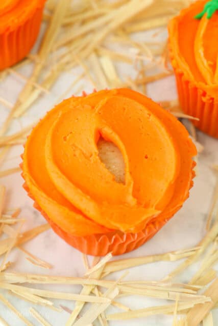 A process shot for decorating pumpkin themed cupcakes for Halloween with orange buttercream