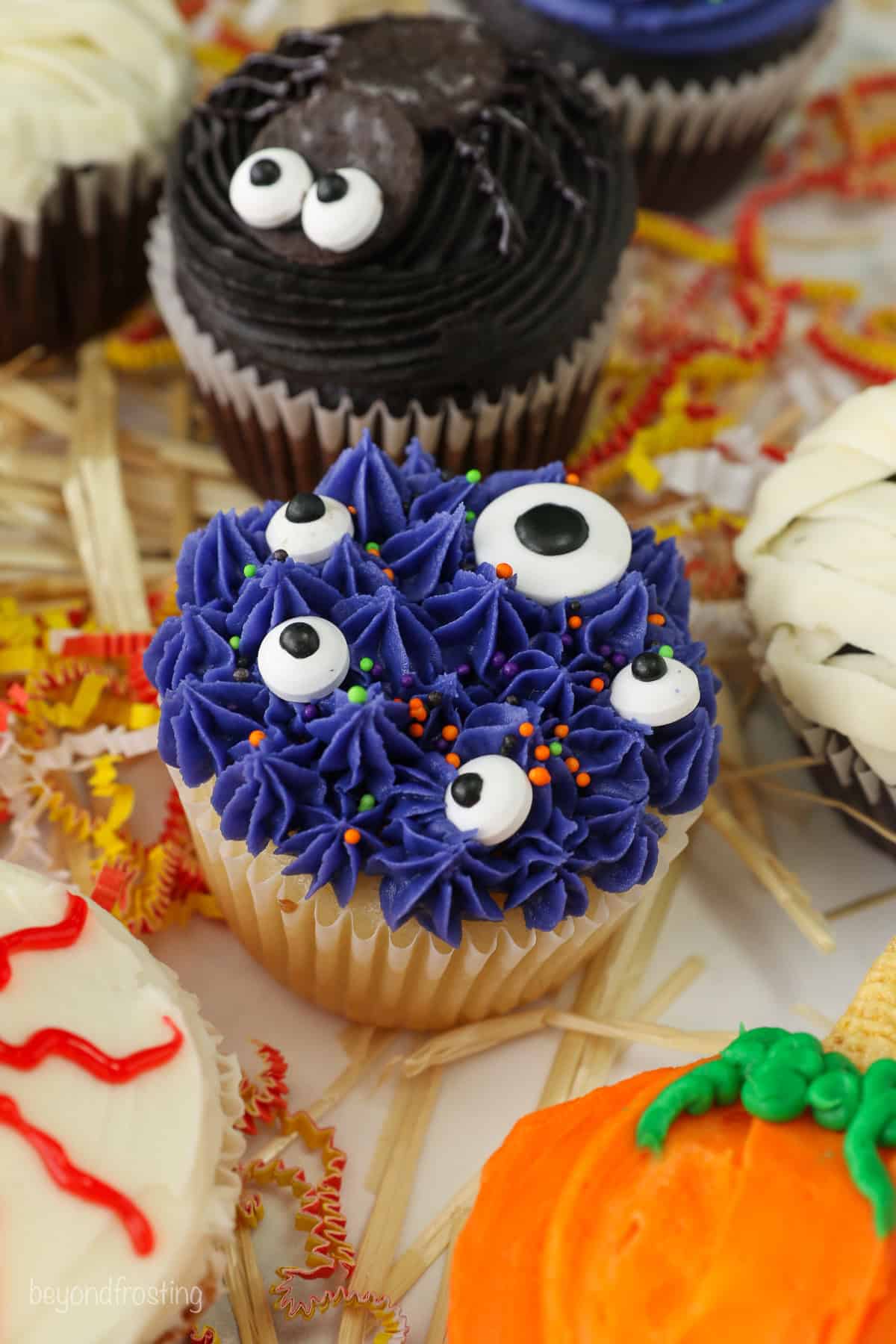 A simple monster themed cupcake for halloween decorated with purple frosting and candy eyes