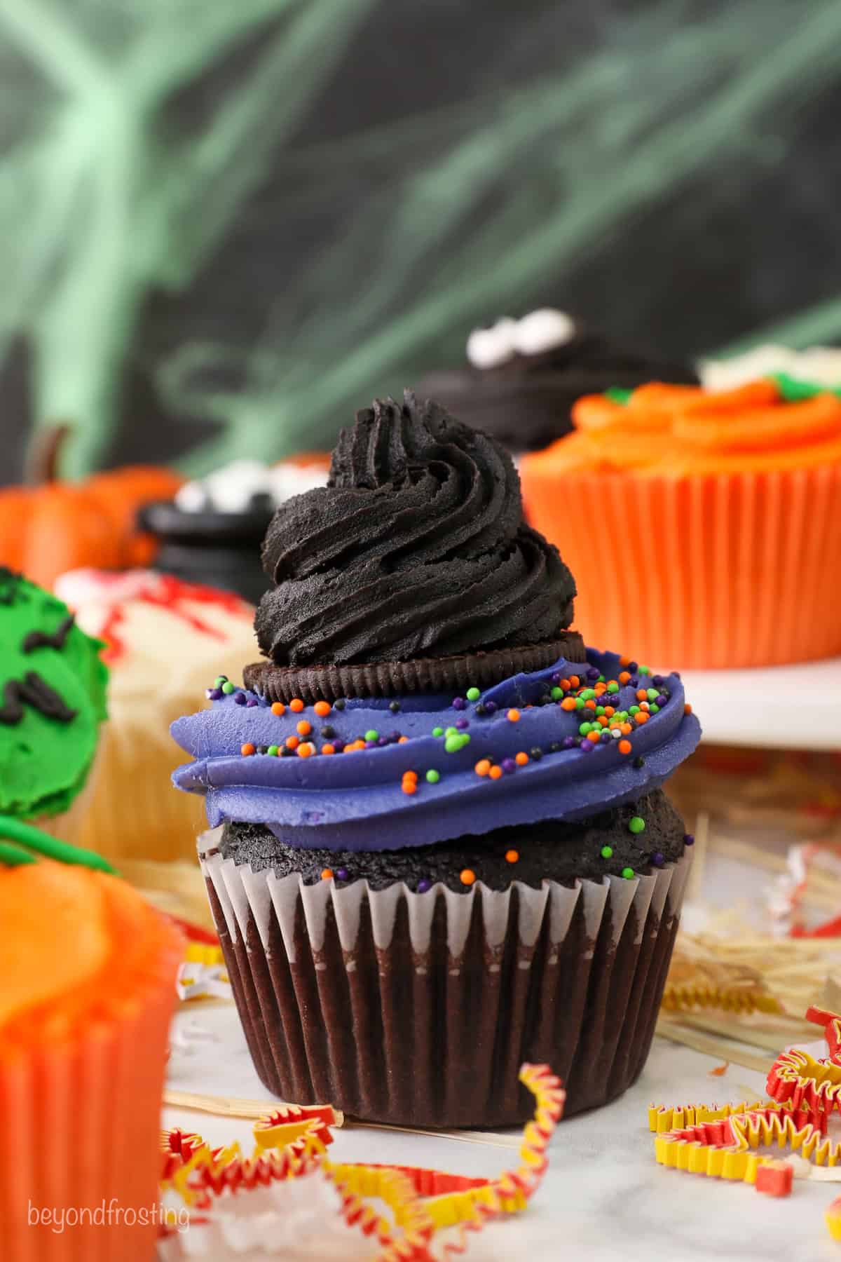 A spooky Witch's hat cupcake decorated for halloween with purple buttercream