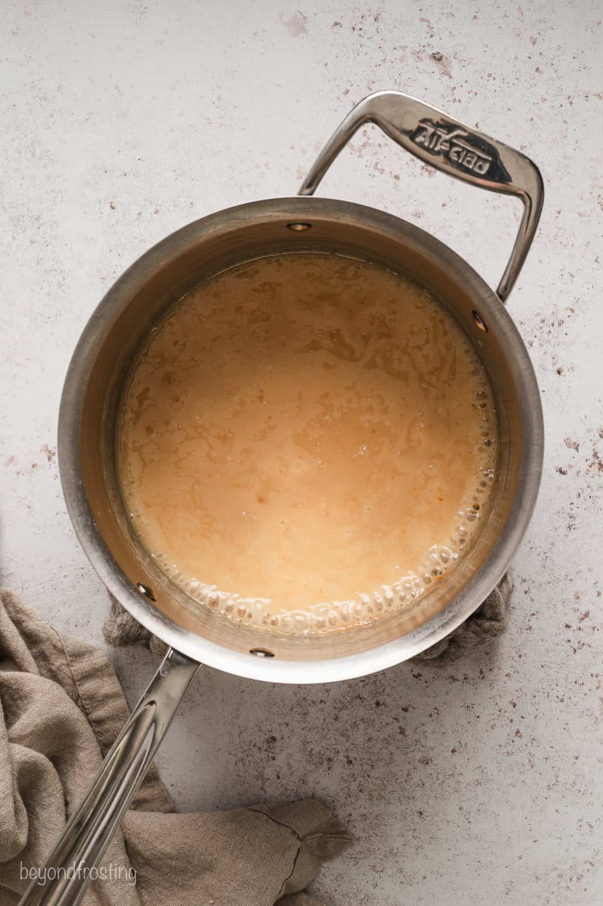 Peanut butter fudge mixture boiling in a saucepan.