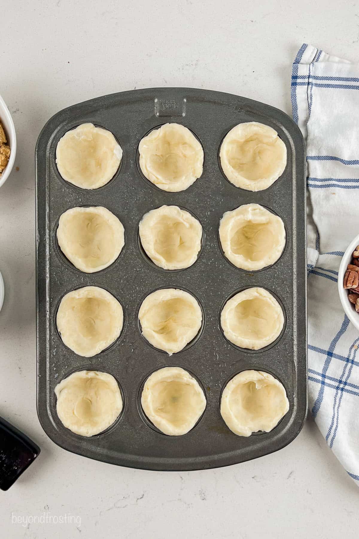 Crusts pressed into a 12-well mini muffin tin.