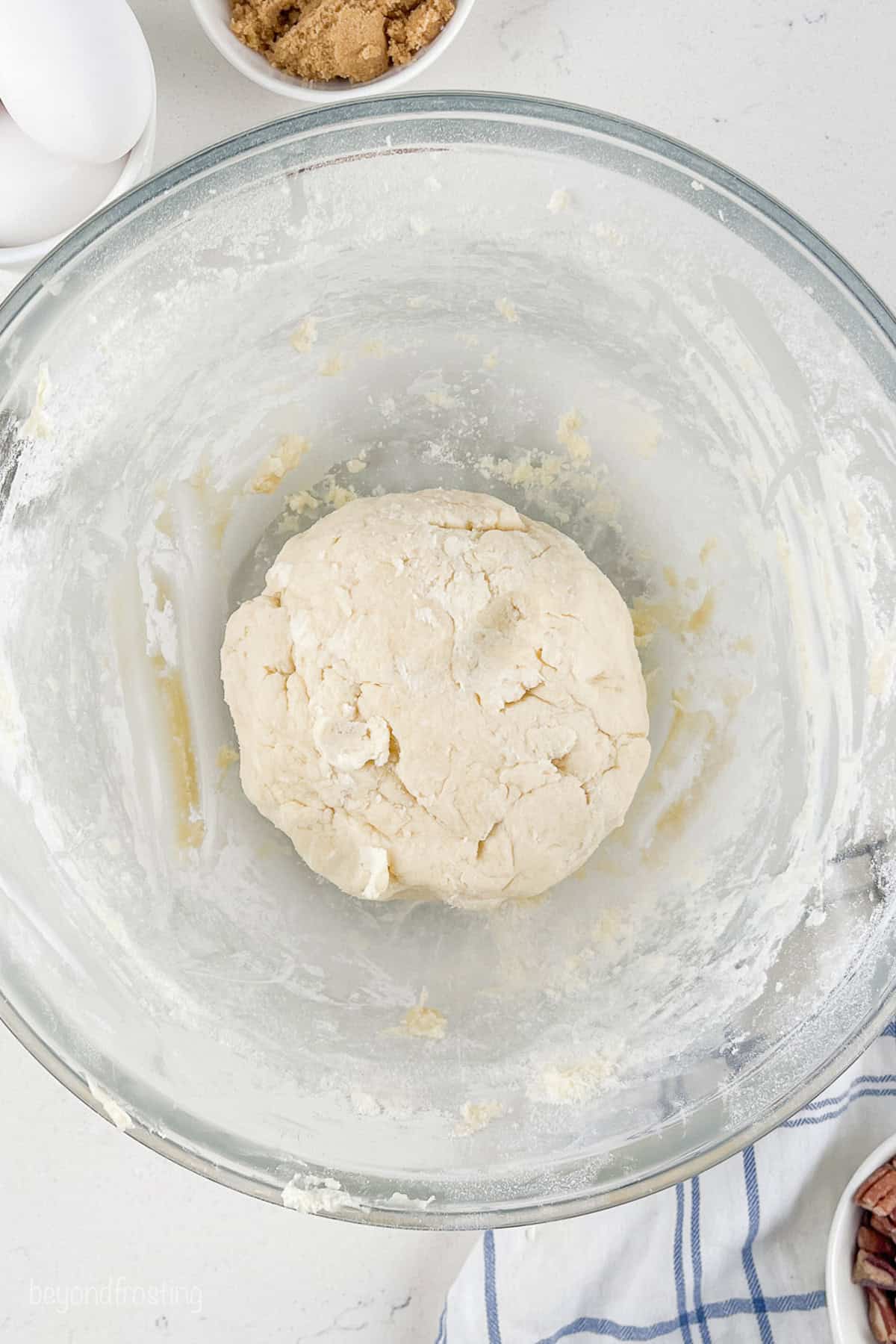 A dough ball in a glass mixing bowl.