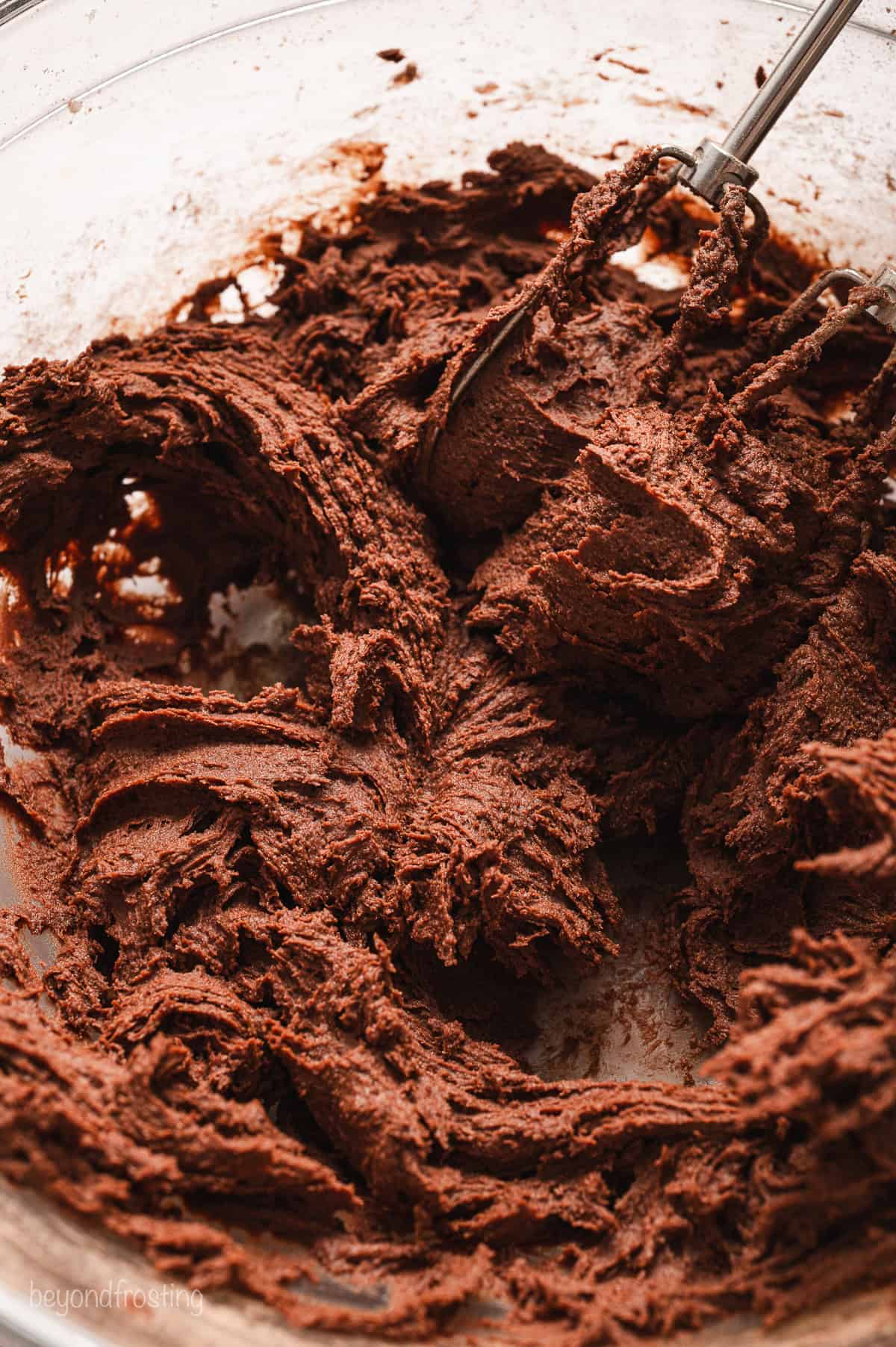 Close up of chocolate cookie dough in a glass bowl.