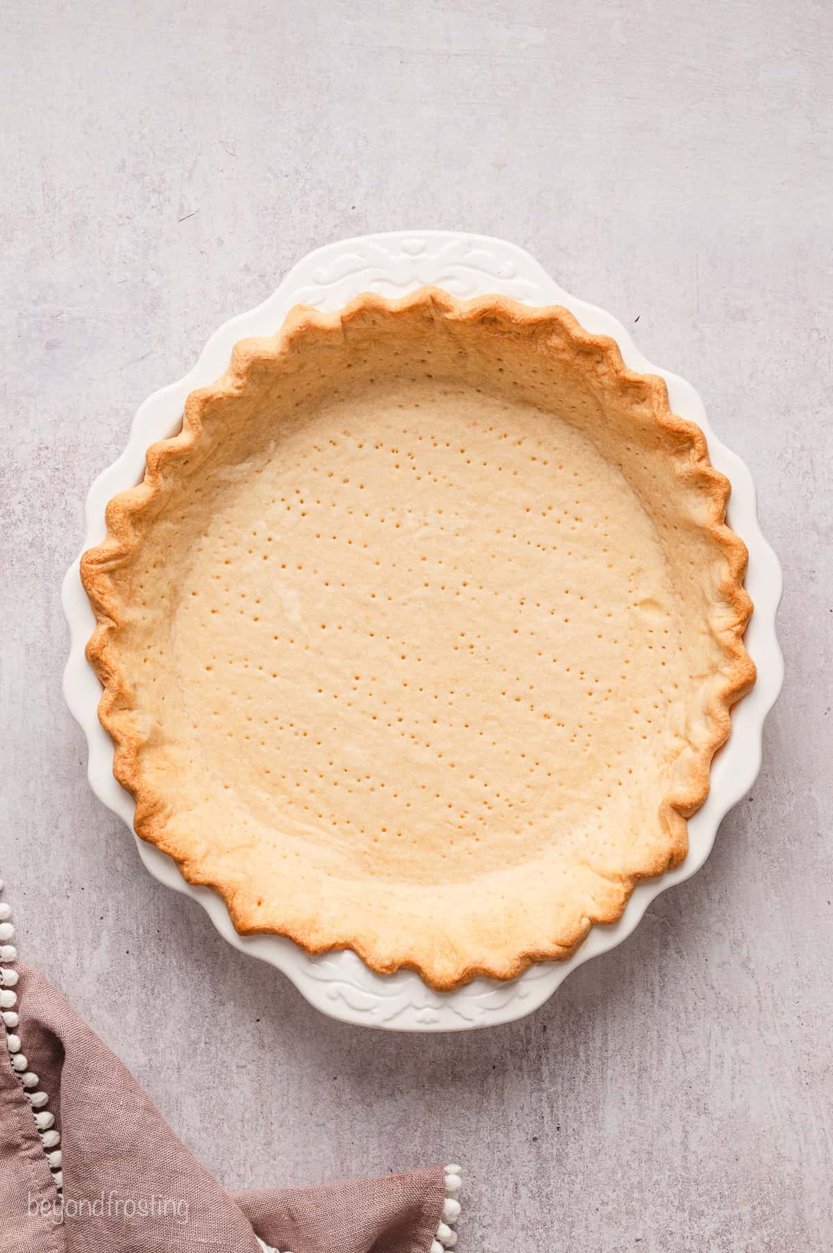 Blind-baked pie crust in a ceramic pie plate.