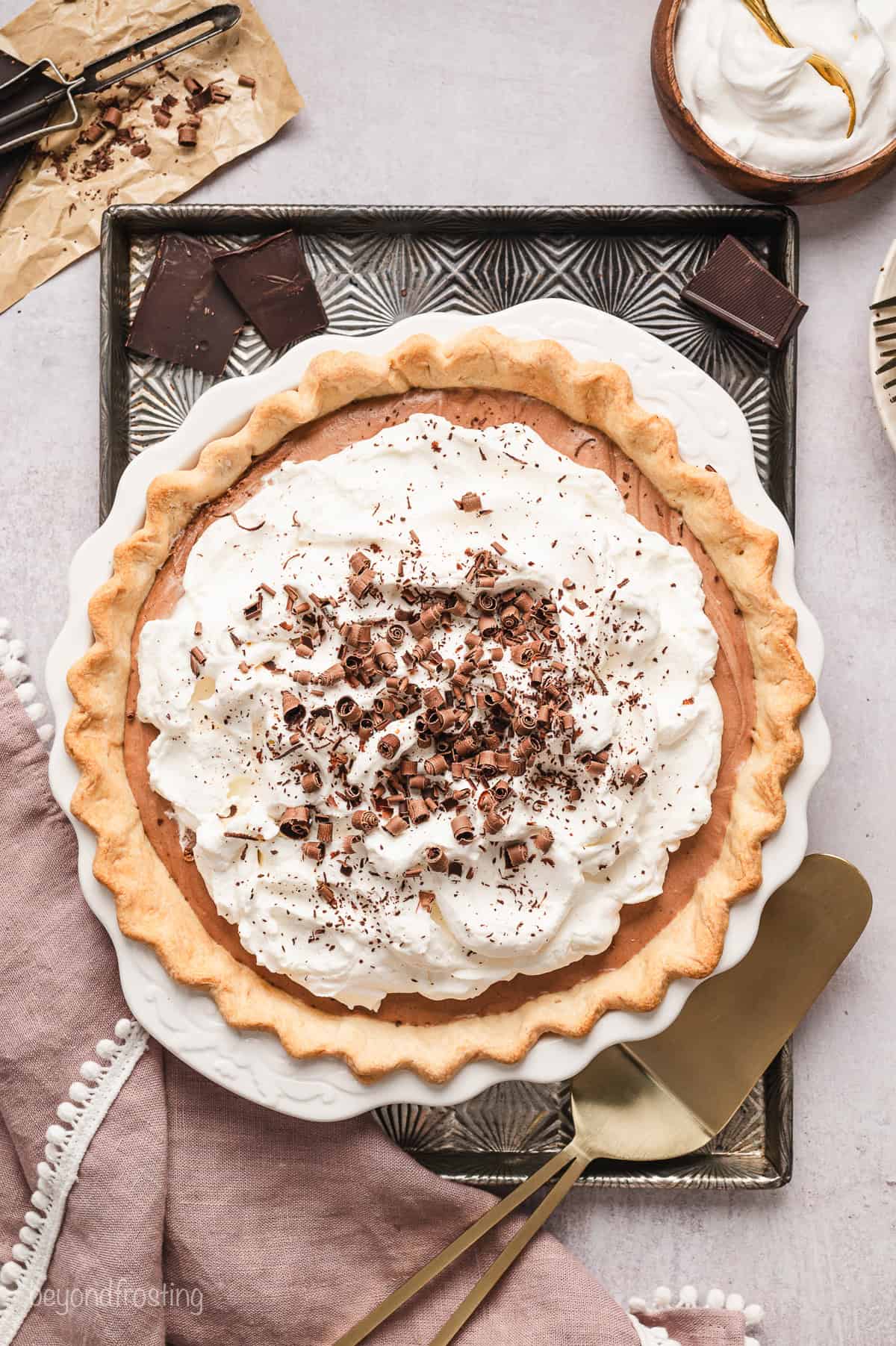 Overhead view of the finished French silk pie topped with whipped cream and garnished with chocolate curls.