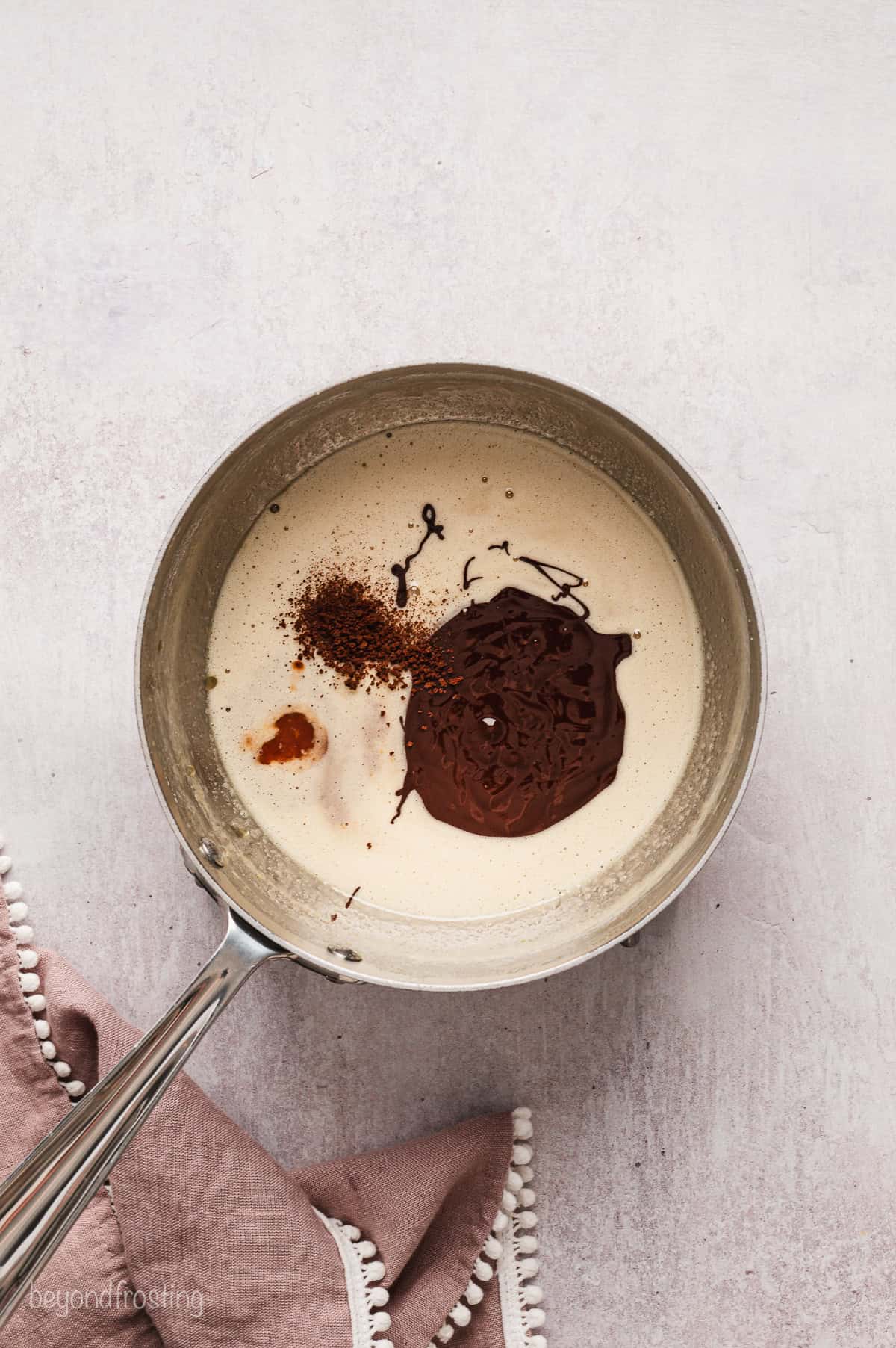 Melted chocolate and espresso powder added to the egg mixture in a saucepan.