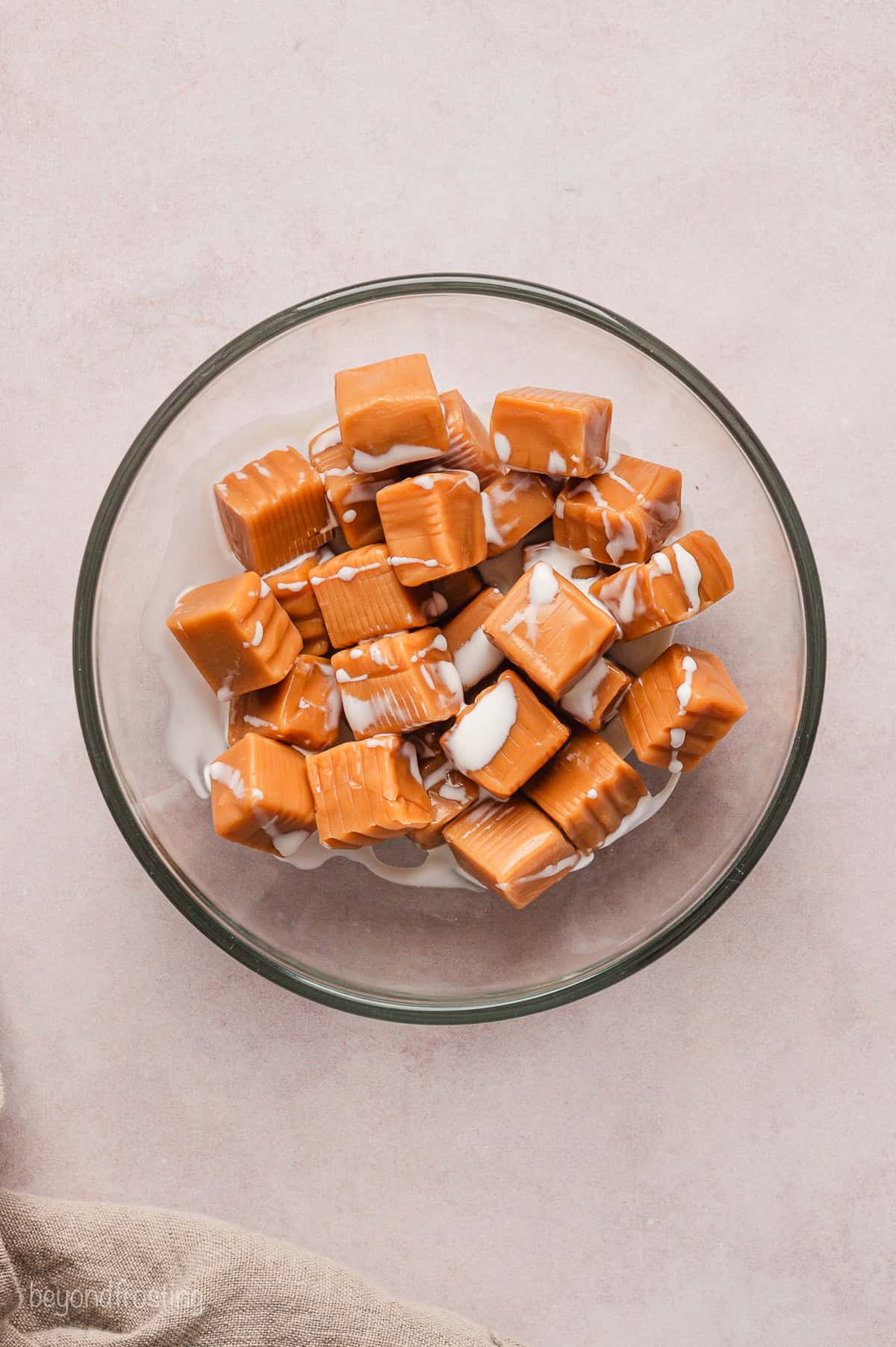 Heavy cream added to a bowl of Kraft soft caramels.