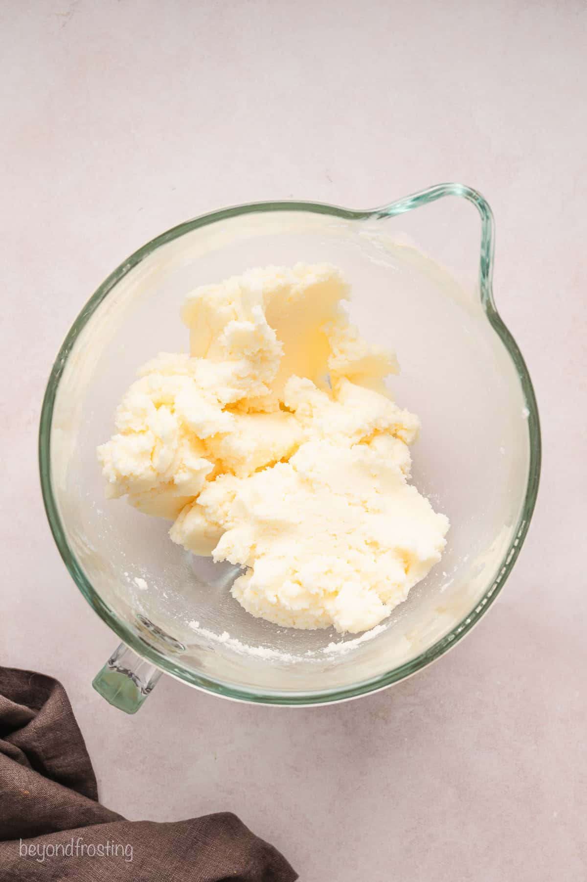 Butter and sugar creamed together in a glass bowl until fluffy.