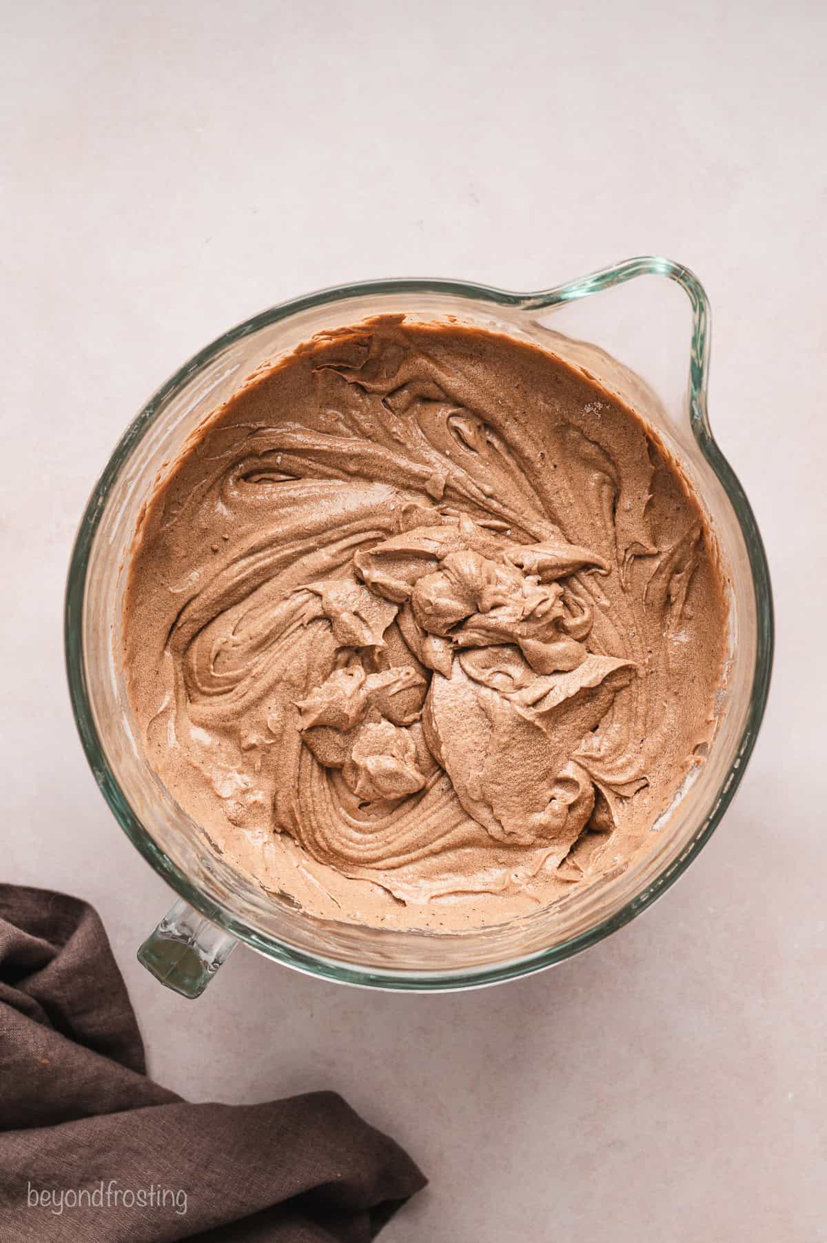 Chocolate cake batter in a glass mixing bowl.