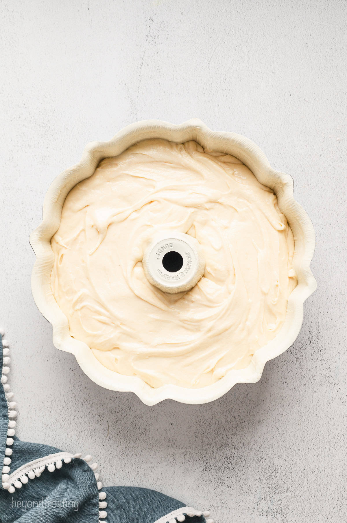 A bundt pan filled with cream cheese pound cake batter.