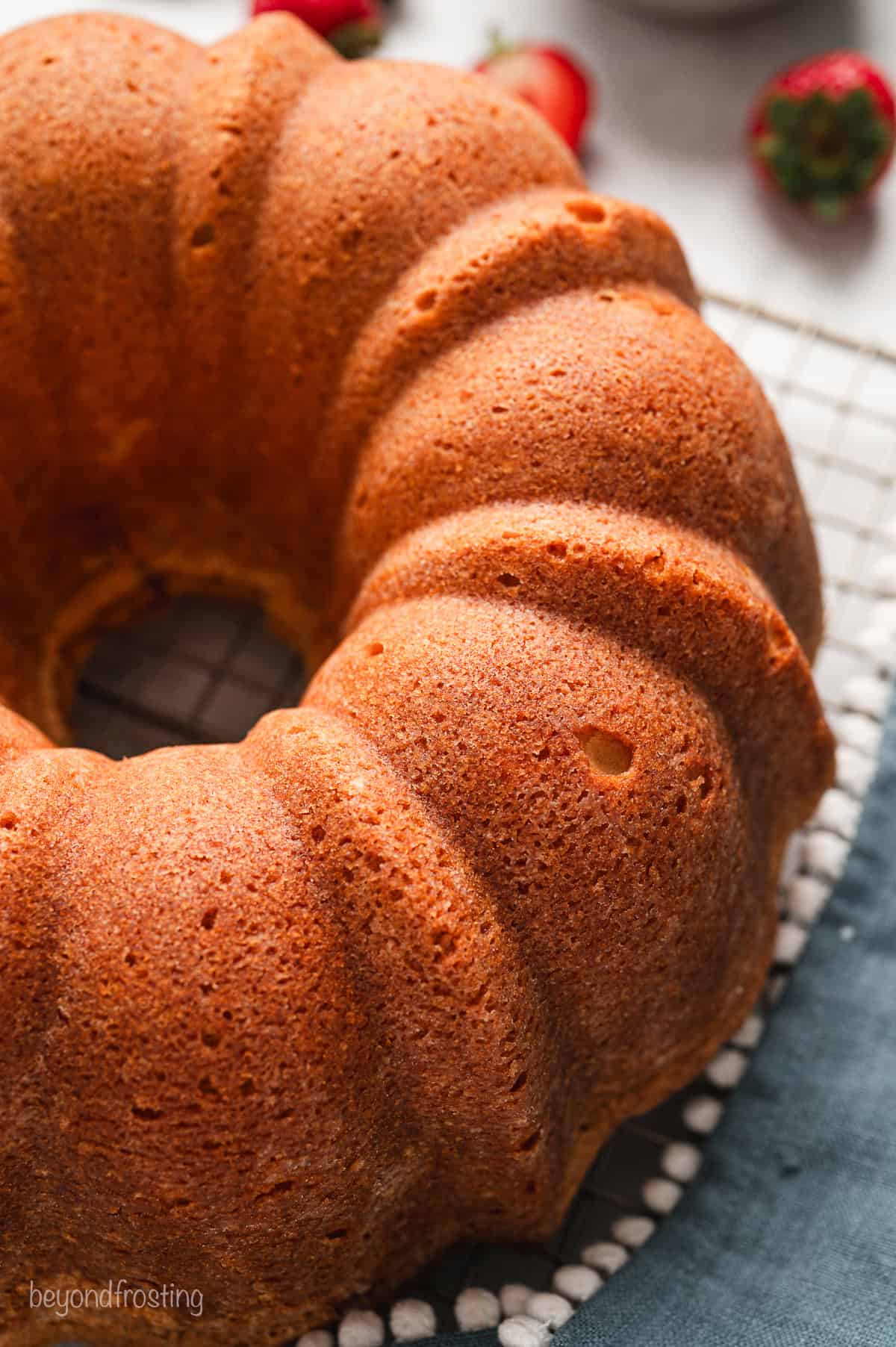 Close up of a cream cheese pound cake on a wire rack.