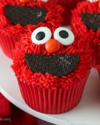 Close up of Elmo cupcakes on a white cake stand.