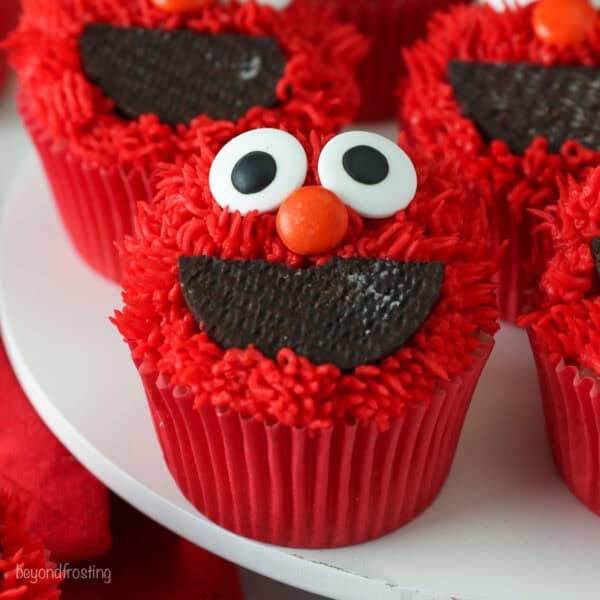 Close up of Elmo cupcakes on a white cake stand.