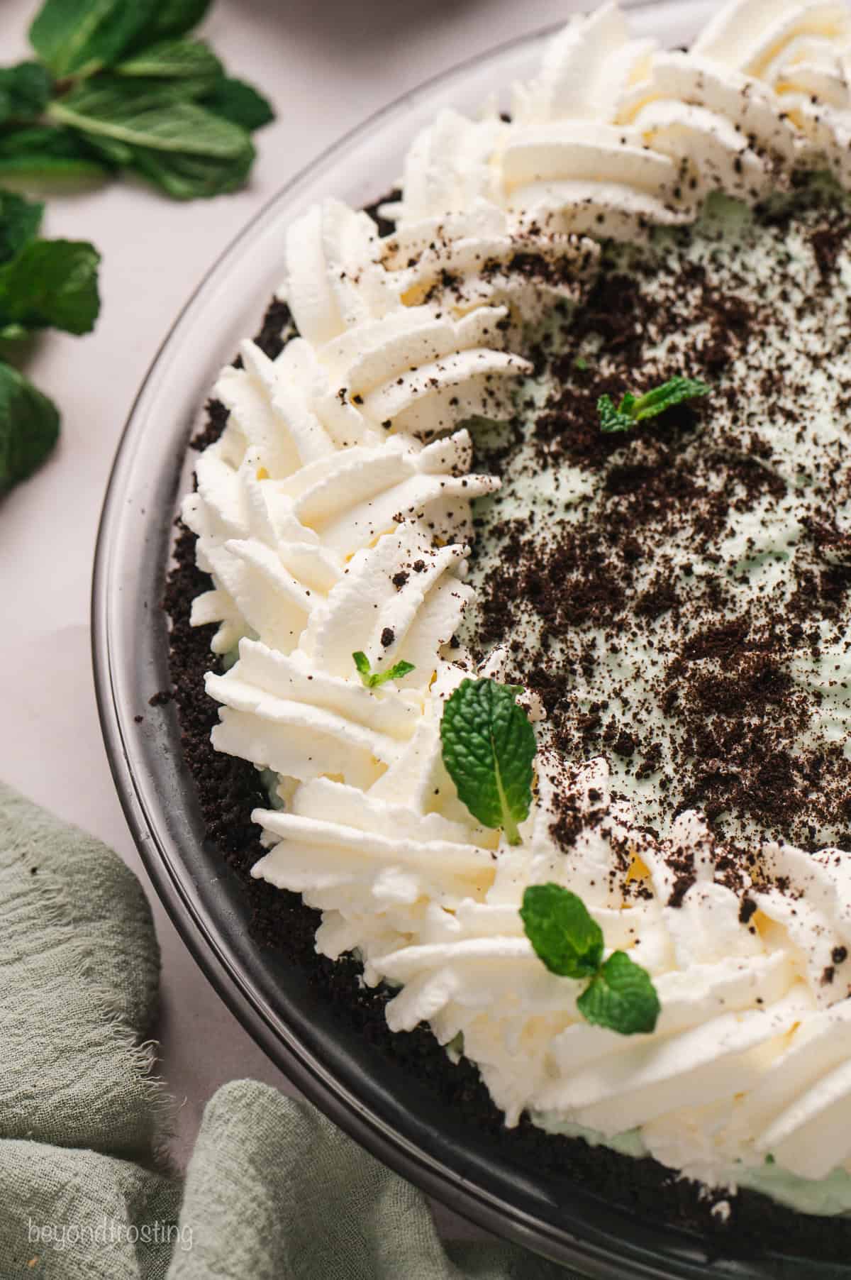 Close up of grasshopper pie garnished with a border of piped whipped cream and chocolate shavings.