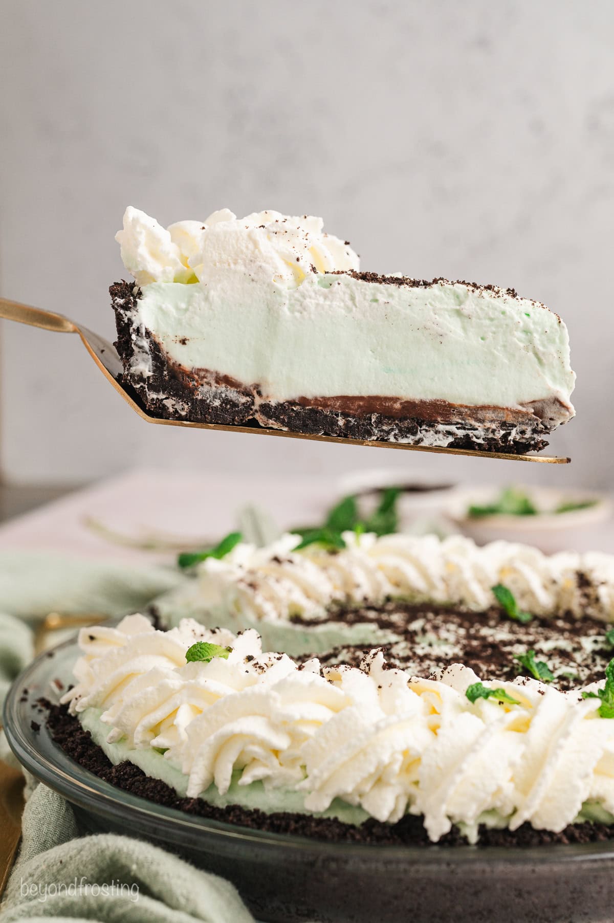 A slice of grasshopper pie lifted from the rest of the pie with a cake server.