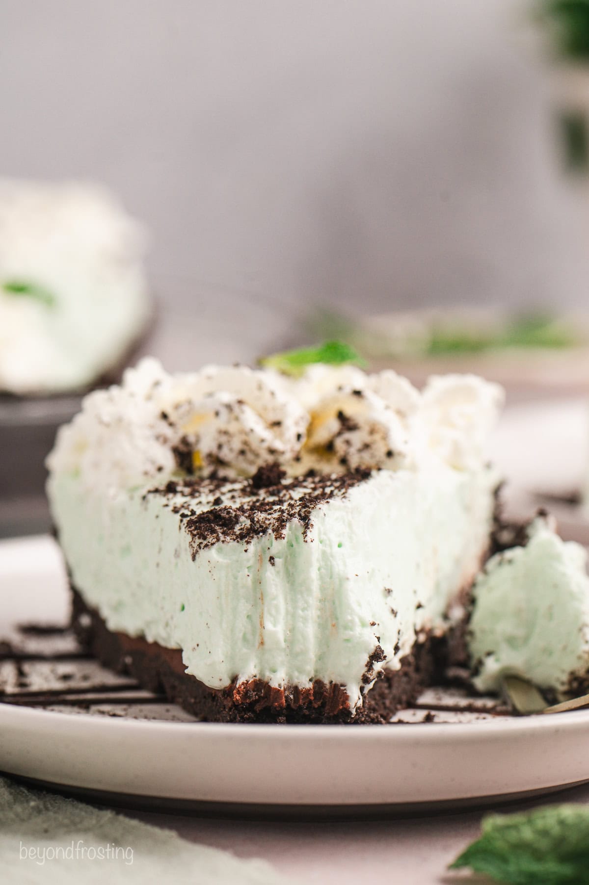 Front view of a slice of grasshopper pie with a forkful missing from the end.