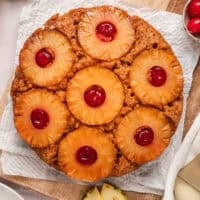 Overhead view of a pineapple upside down cake on a parchment-lined cutting board.